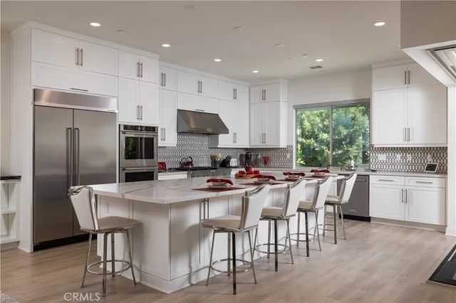 a kitchen with appliances a sink and cabinets