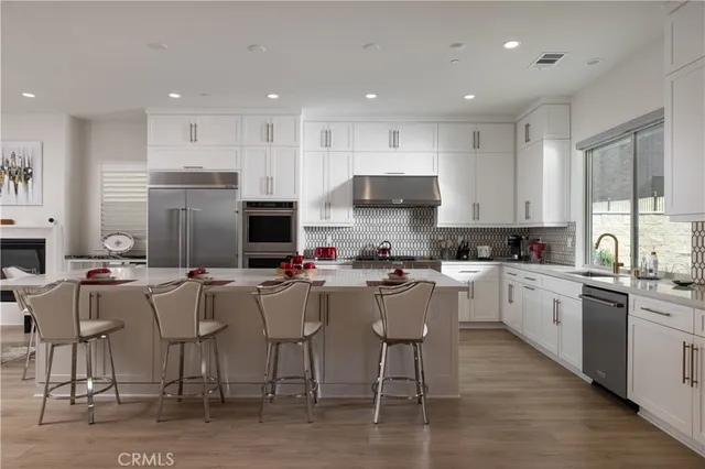 a kitchen with appliances cabinets and a chair