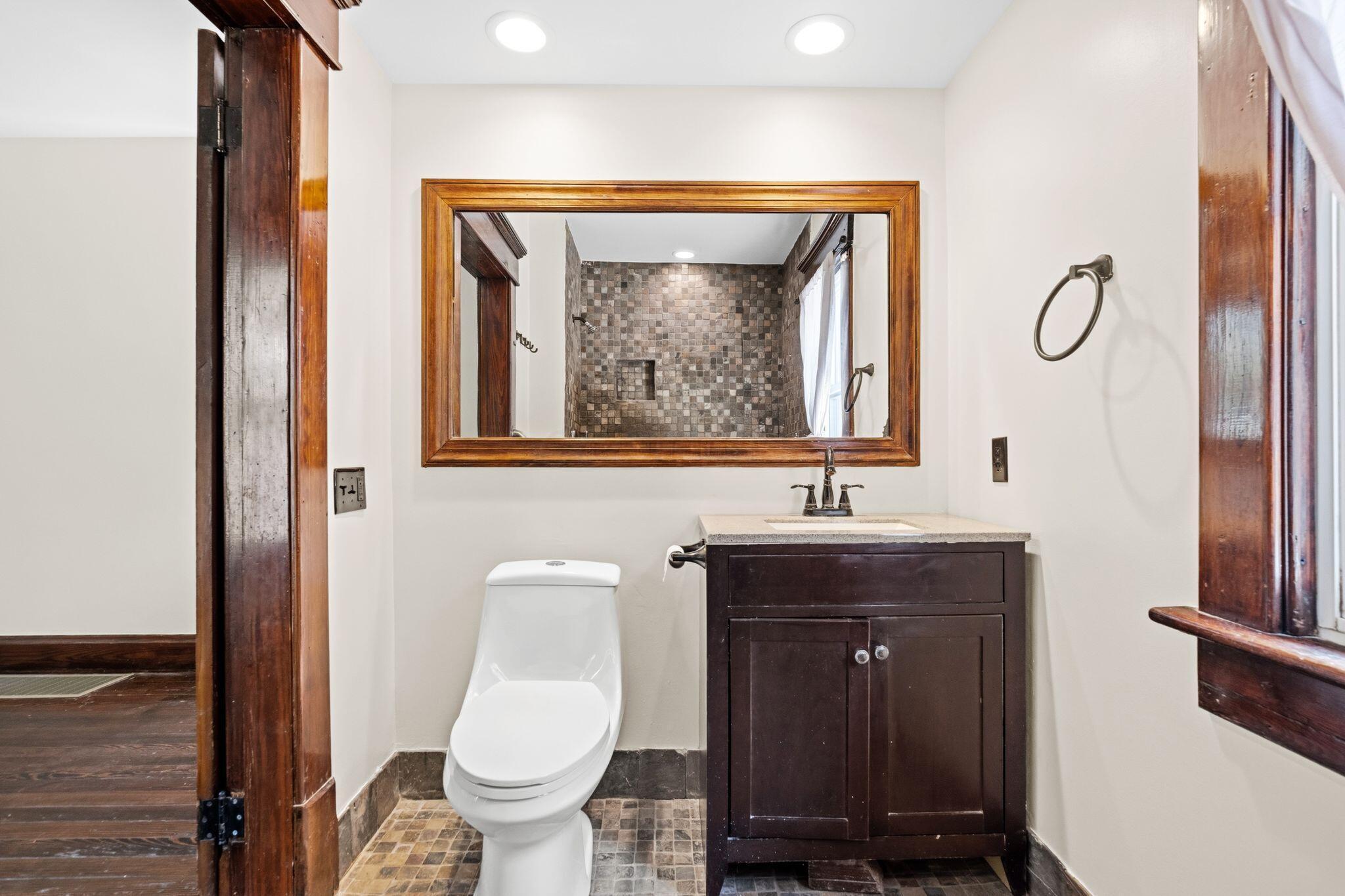107 Price Road Columbus, OH 43230 - Photo 14 of 51 Bathroom featuring a dark wood-finish vanity with a light countertop, a white toilet, and a large wood-framed mirror