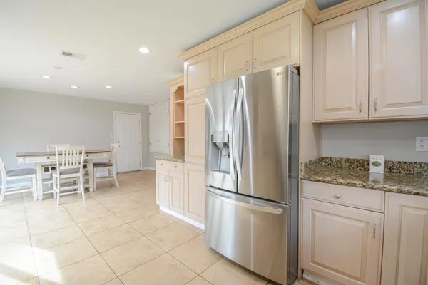a kitchen with stainless steel appliances granite countertop a refrigerator and a stove top oven