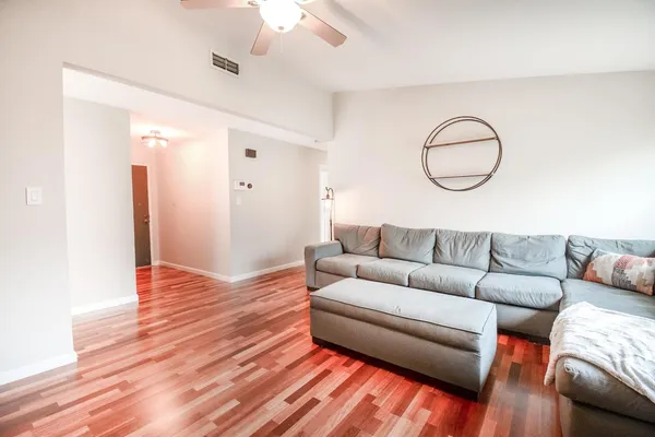 a living room with furniture and a wooden floor