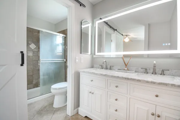a bathroom with a granite countertop sink toilet and shower