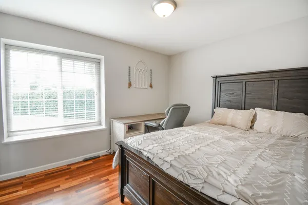a bedroom with a bed and wooden floor