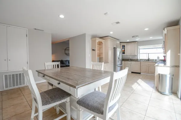 a kitchen with a table chairs refrigerator and stove