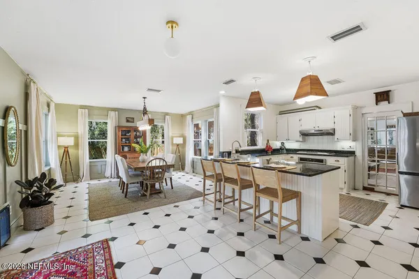 a spacious bedroom with a large bed and a chandelier