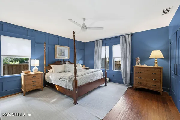 a spacious bedroom with a large bed and a chandelier