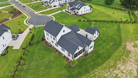 an aerial view of a house with a garden and swimming pool