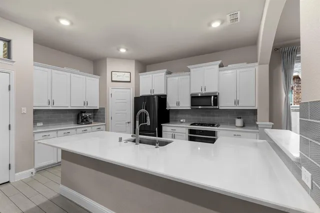 a kitchen with appliances a sink and cabinets