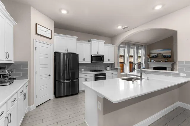 a kitchen with a refrigerator a sink and cabinets