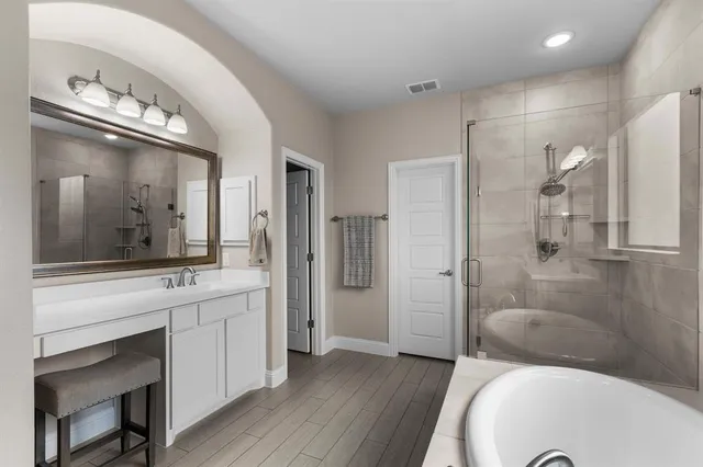 a spacious bathroom with a granite countertop sink a toilet a mirror and shower