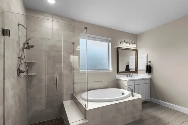 a bathroom with a sink a toilet a mirror and shower