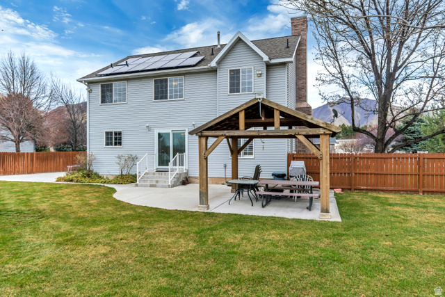 1697 North 500 West Mapleton, UT 84664 - Photo 34 of 50 Back of house featuring a patio, a fenced backyard, roof mounted solar panels, a chimney, and roof with shingles