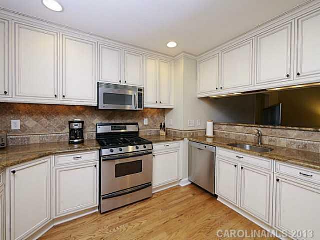 4216 Murrayhill Road Charlotte, NC 28209 - Photo 8 of 16 a kitchen with white cabinets and stainless steel appliances