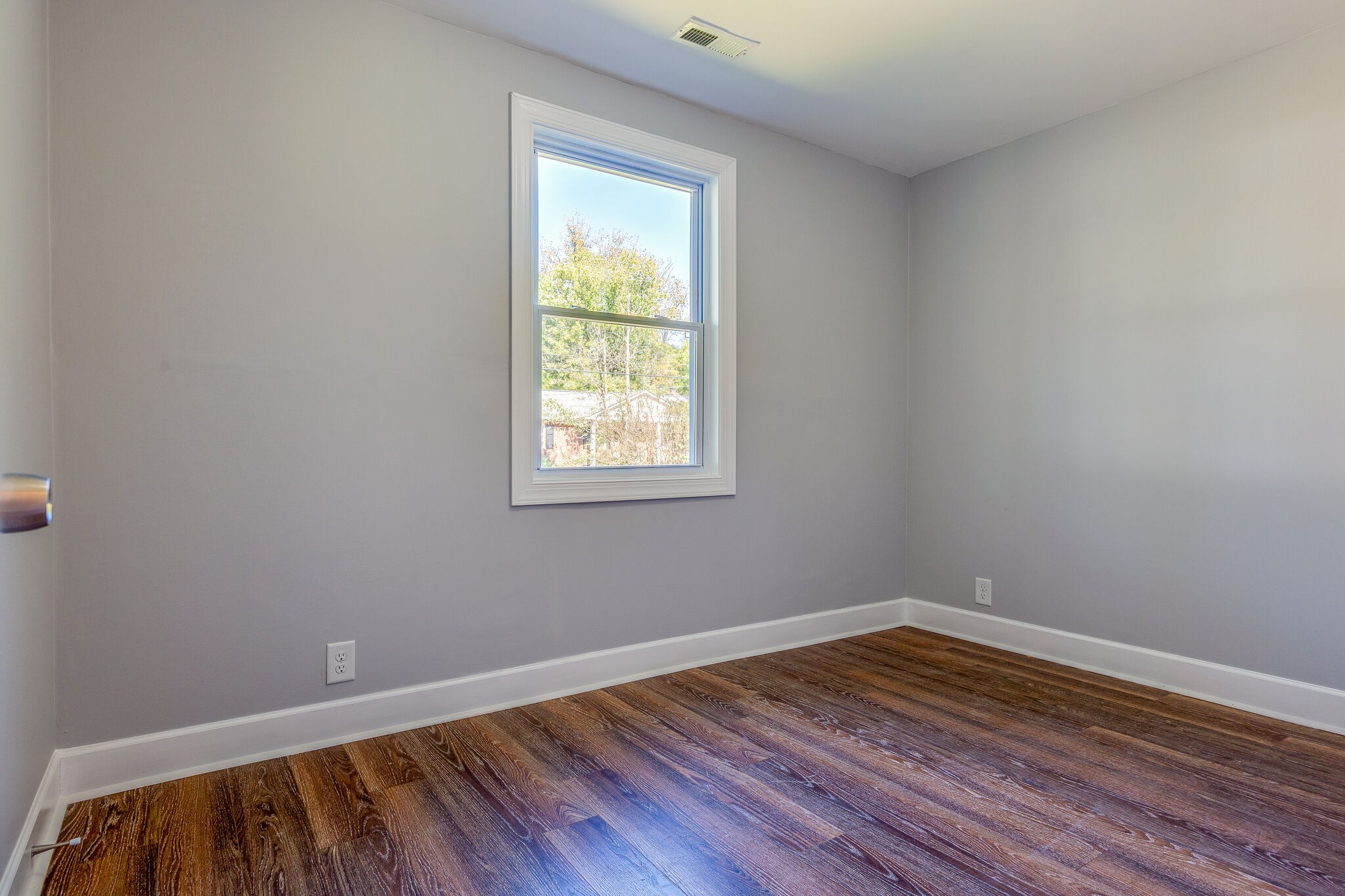 75 Benzing Road Antioch, TN 37013 - Photo 12 of 23 an empty room with wooden floor and windows