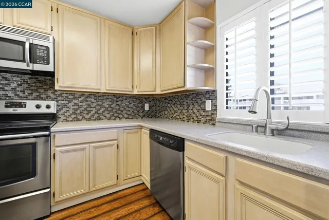 a kitchen with stainless steel appliances white cabinets and a stove top oven
