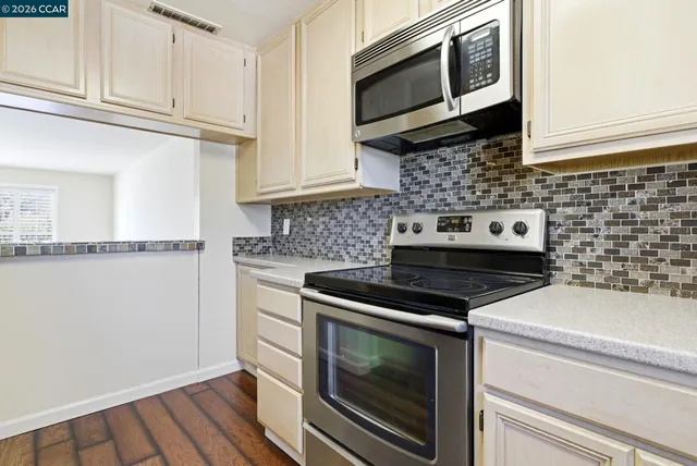 a kitchen with granite countertop a stove microwave and sink