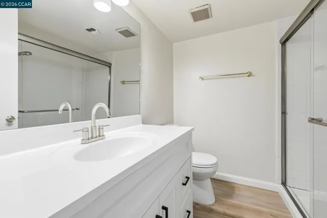 a bathroom with a sink a toilet a shower and a mirror