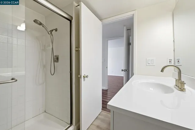 a bathroom with a sink vanity and shower