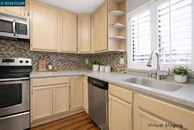 a kitchen with stainless steel appliances granite countertop a sink a stove and cabinets