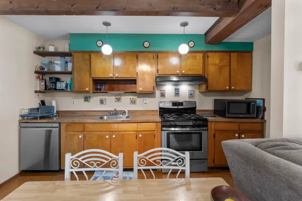 a living room with stainless steel appliances kitchen island granite countertop furniture and a large window