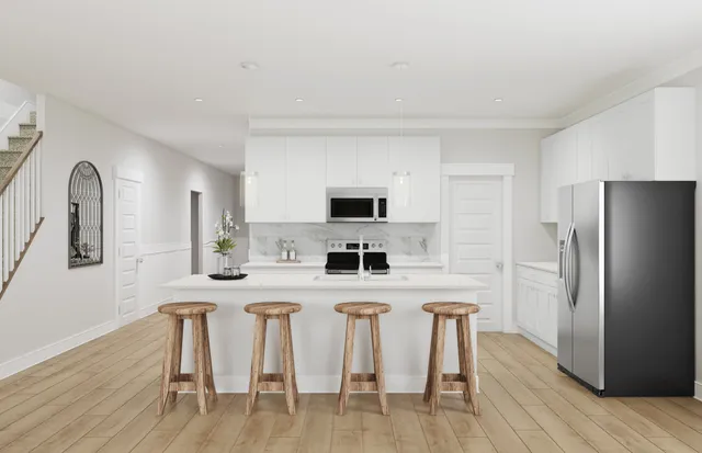 a kitchen with stainless steel appliances a dining table chairs refrigerator and sink