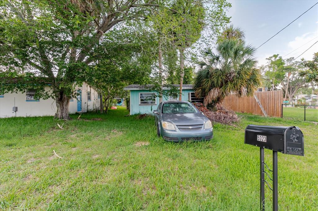 5323 Circle Drive Weeki Wachee, FL 34607 - Photo 37 of 77 a view of a backyard with table and chairs potted plants and large tree