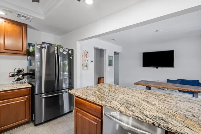 a kitchen with stainless steel appliances granite countertop a refrigerator and a stove top oven