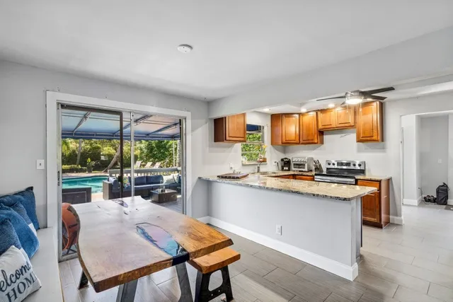 a kitchen with a stove a refrigerator a sink dishwasher with a dining table and chair