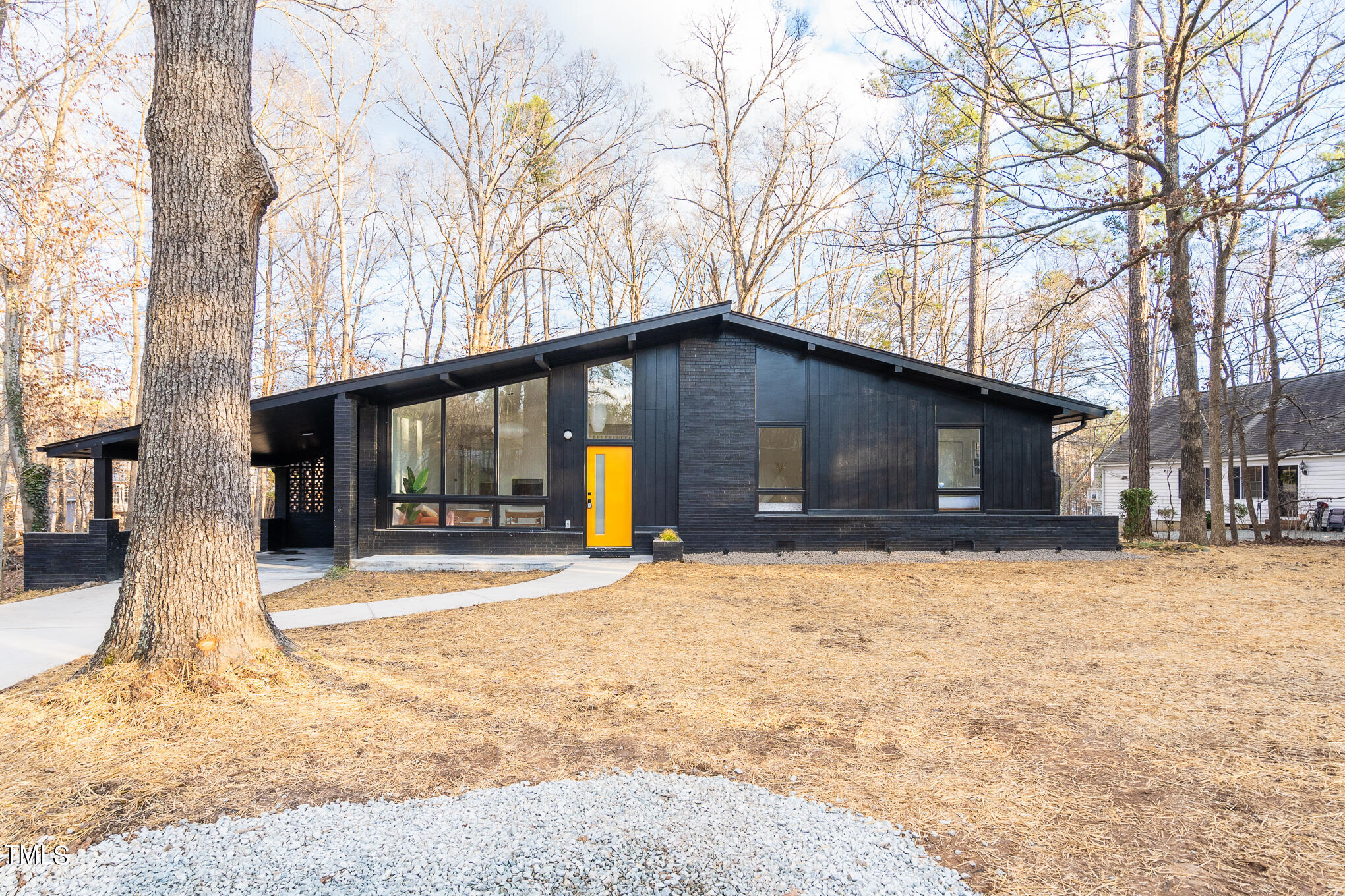 a front view of a house with a yard covered in snow