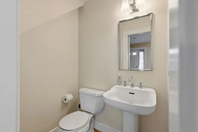 a bathroom with a toilet sink and mirror