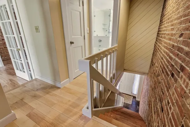 a view of a hallway with wooden floor and staircase