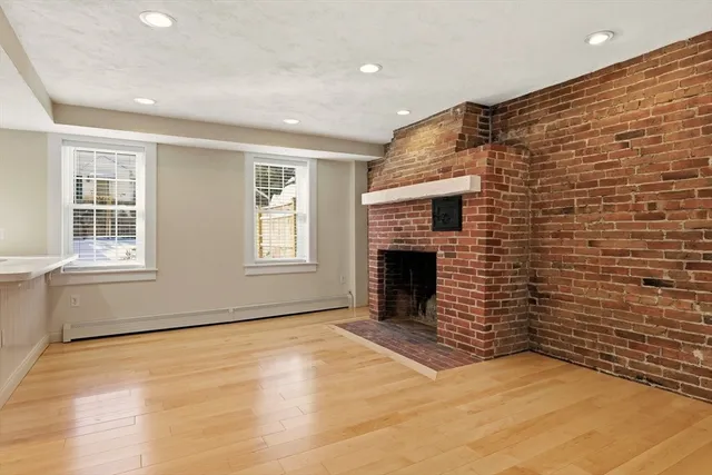 a view of an empty room with a fireplace and a window