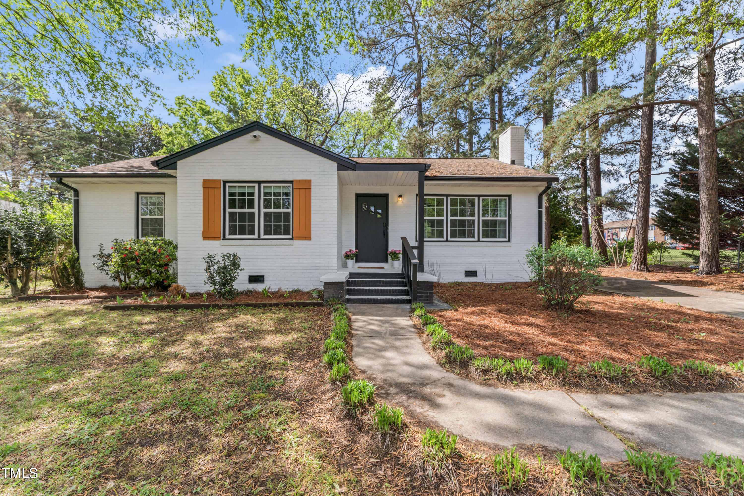 a front view of house with yard and trees around