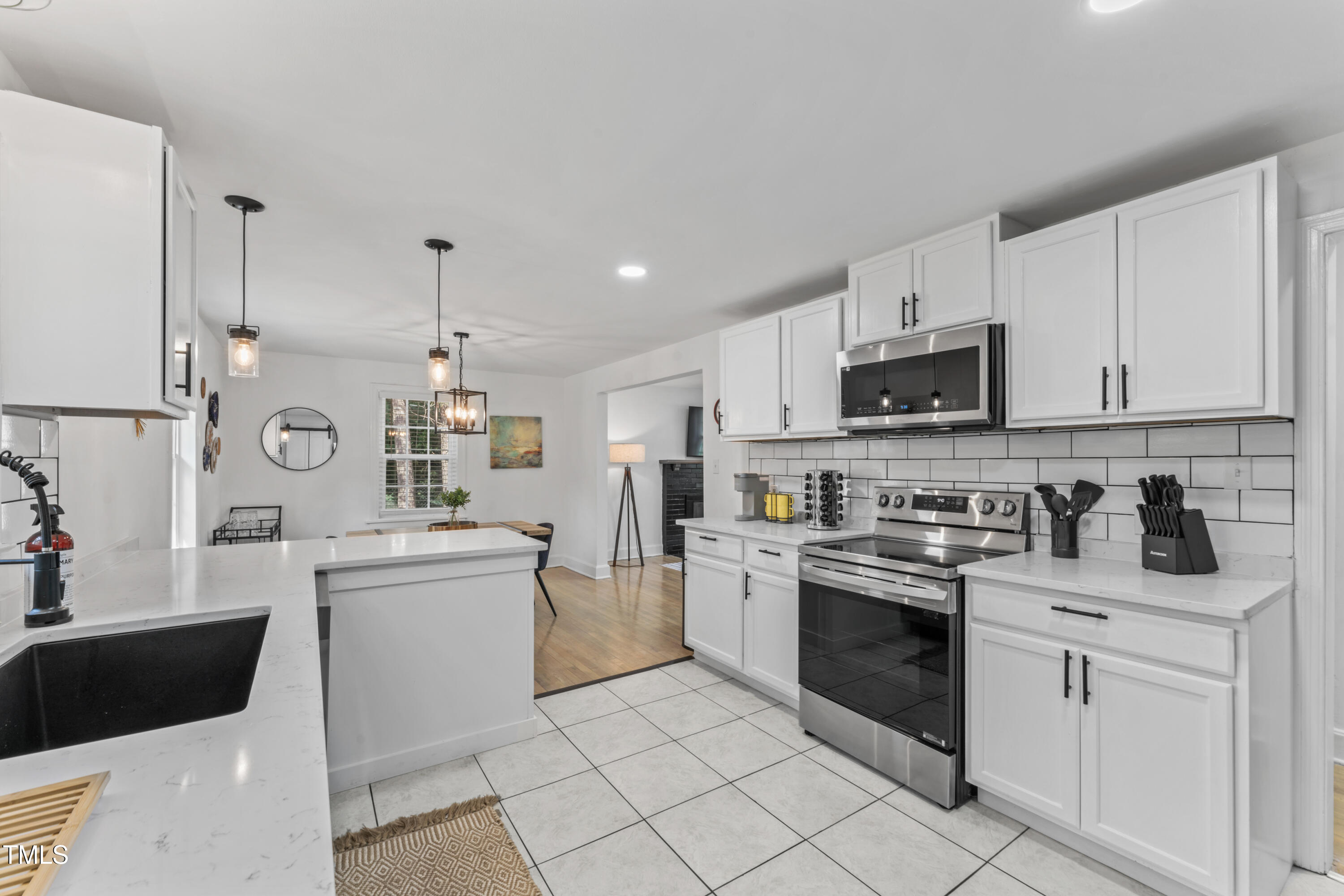 711 Horton Road Durham, NC 27704 - Photo 15 of 28 a kitchen with white cabinets stainless steel appliances and sink