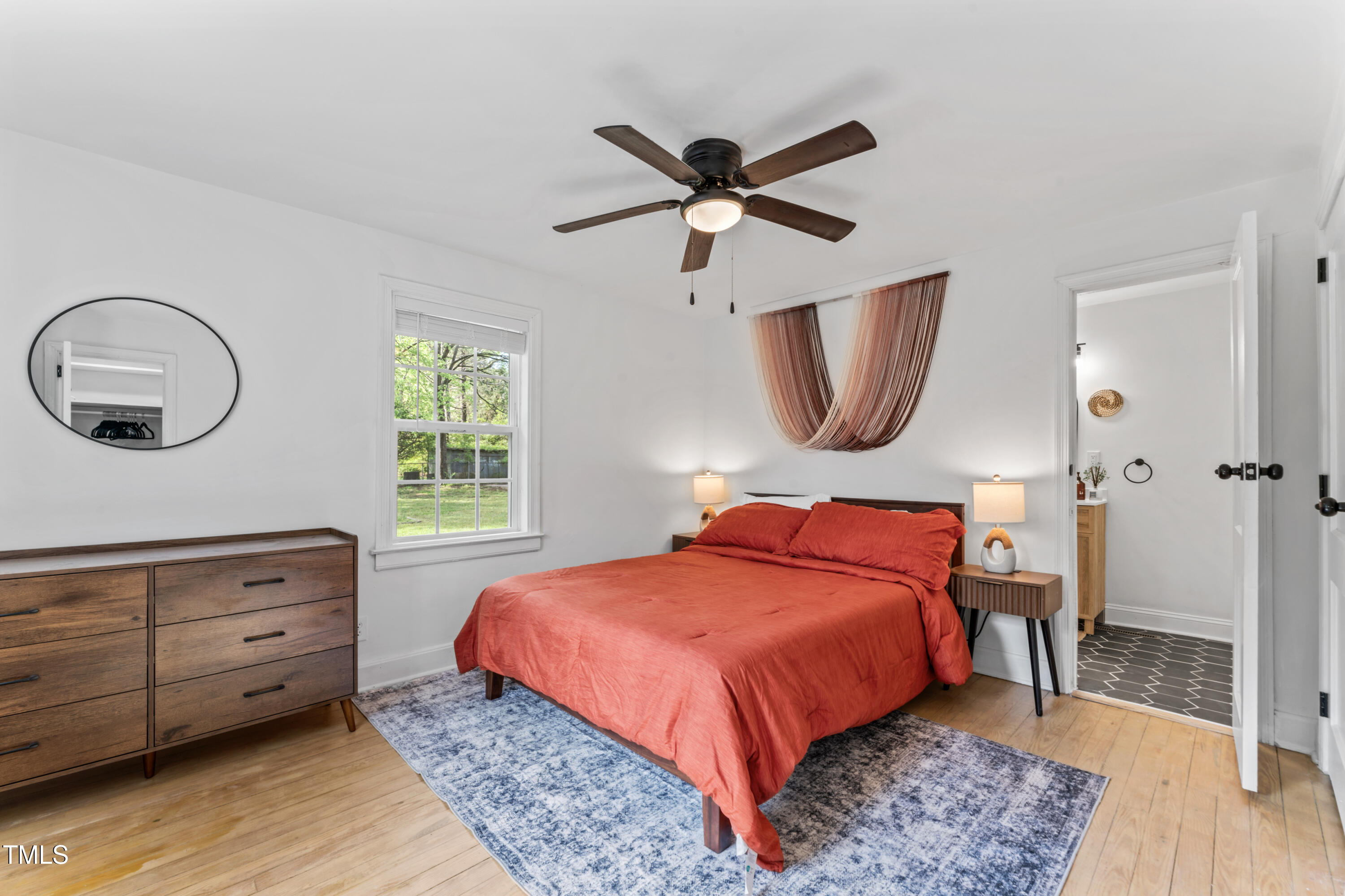 711 Horton Road Durham, NC 27704 - Photo 20 of 28 a bedroom with a bed and a mirror on dresser
