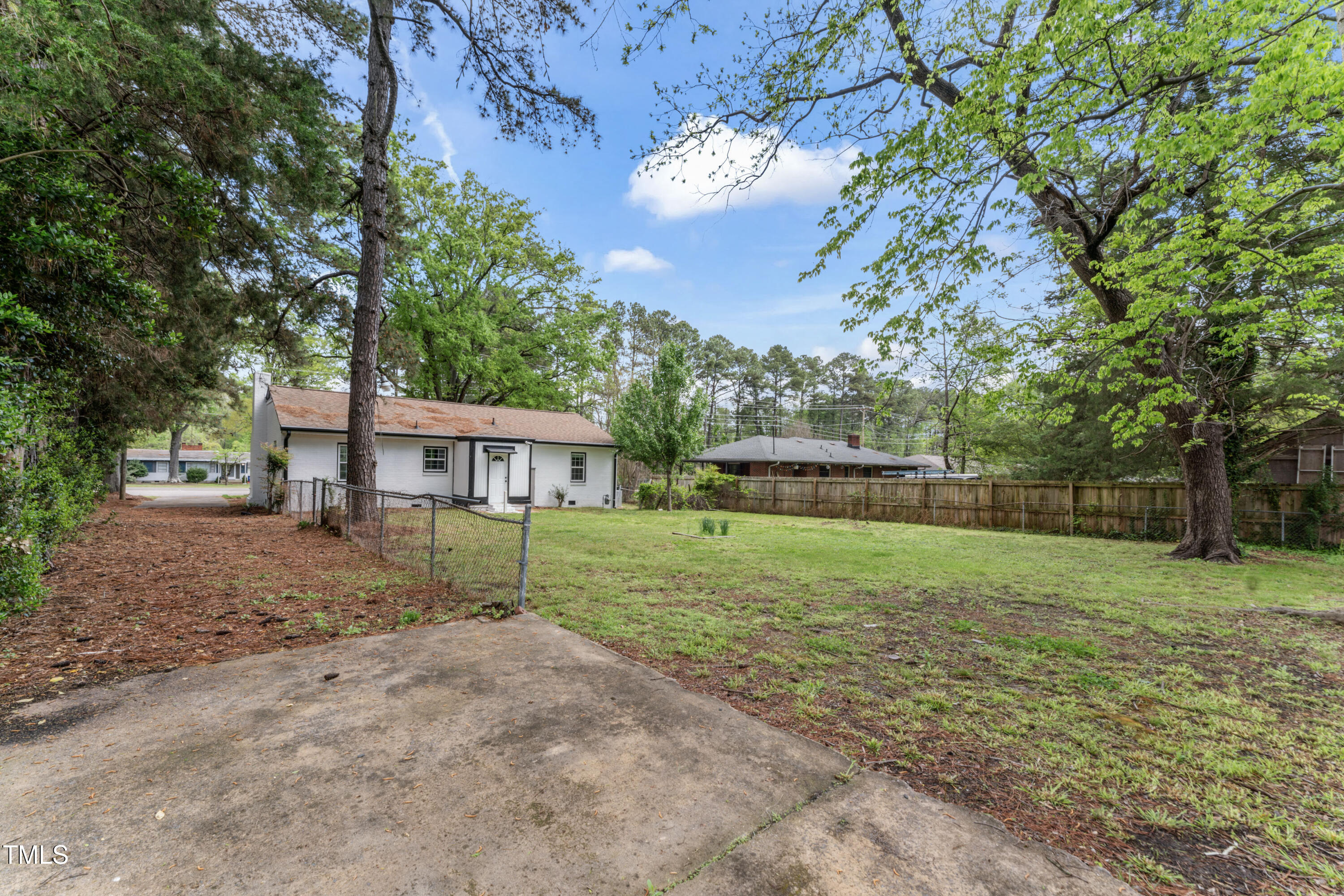 711 Horton Road Durham, NC 27704 - Photo 26 of 28 a view of a big house in a big yard with large trees