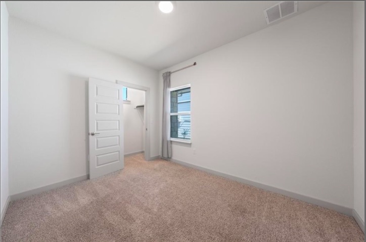 10805 Meris Lane Austin, TX 78754 - Photo 17 of 28 A well-lit bedroom with soft carpeting and a window offering natural illumination.