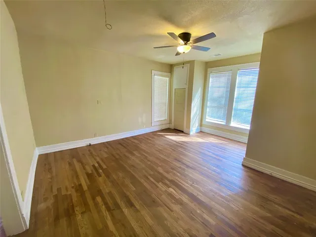 a view of an empty room with wooden floor