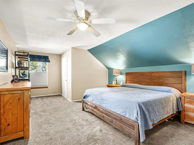 a bedroom with a large bed a flat tv screen and dresser