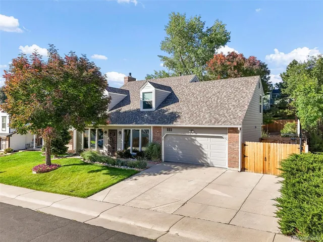 a front view of a house with a yard and trees
