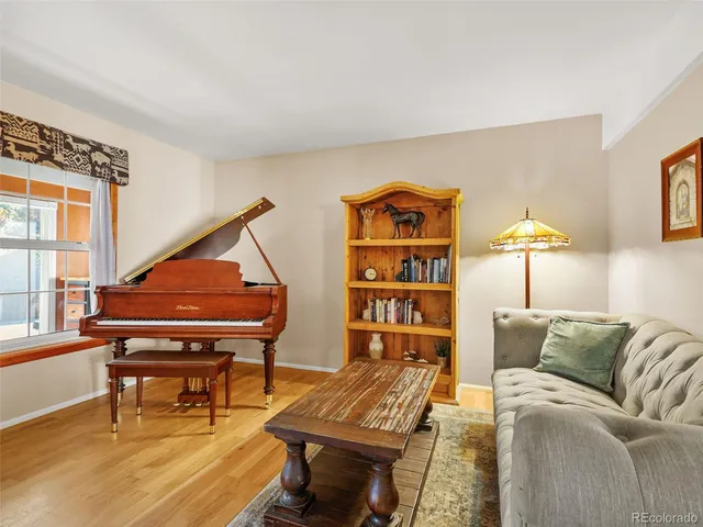 a living room with furniture and a piano