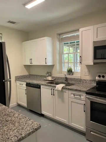 a kitchen with stainless steel appliances granite countertop a stove a sink and a refrigerator