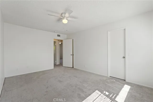 an empty room with a ceiling fan and a window