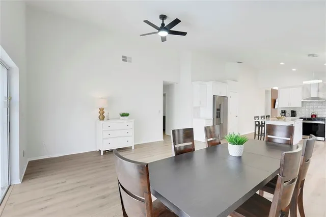 a kitchen with a dining table chairs and white cabinets