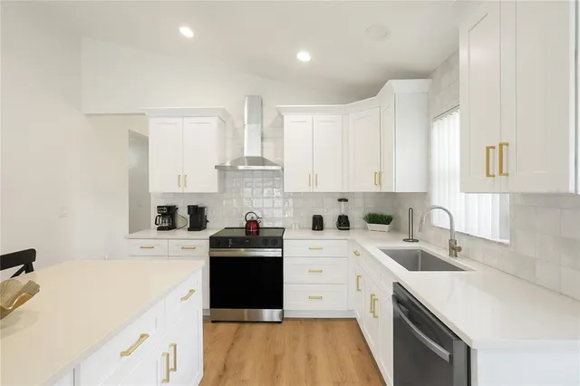 a kitchen with granite countertop a stove top oven and refrigerator