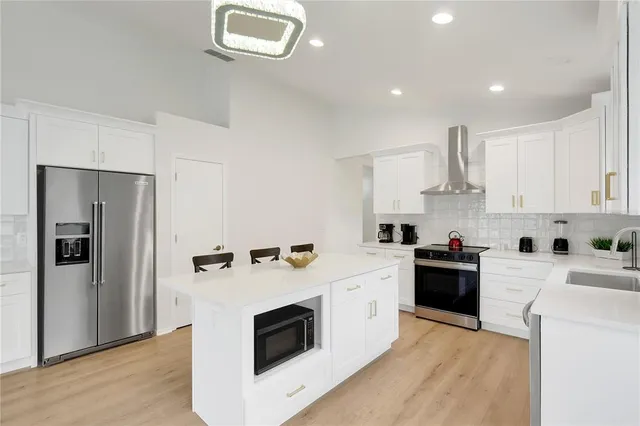 a bedroom with a large bed and a chandelier