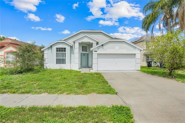 a front view of a house with a garden and yard