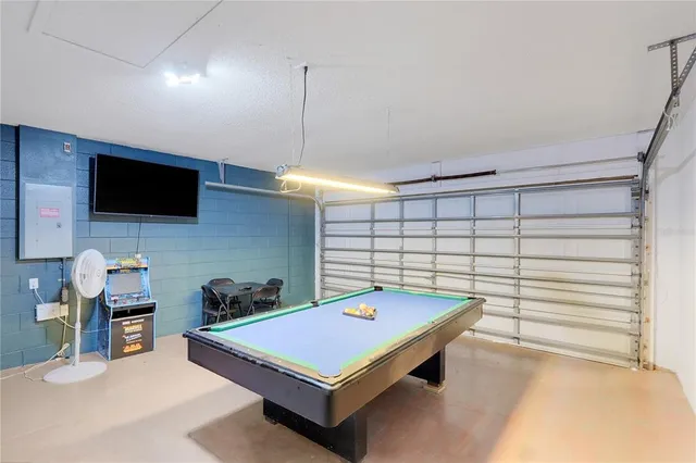 a room with pool table and windows