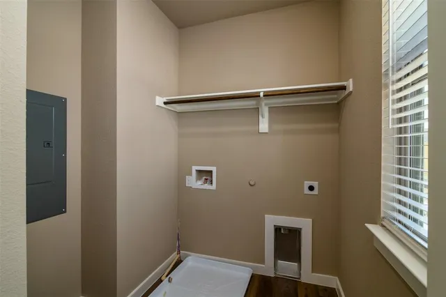 an empty room with a chandelier fan and windows