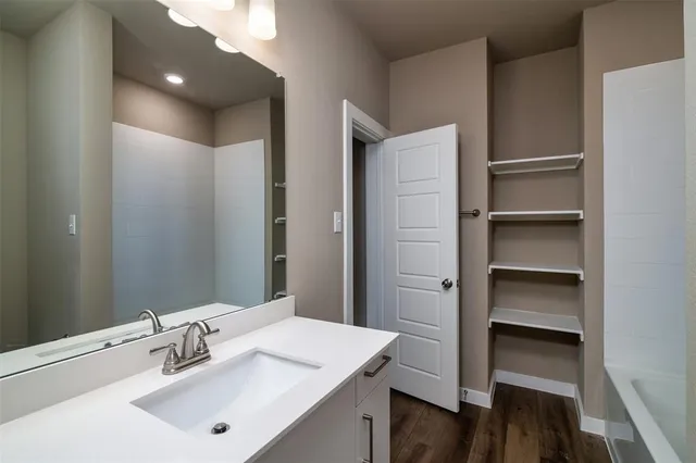 a bathroom with a granite countertop bathtub shower and toilet